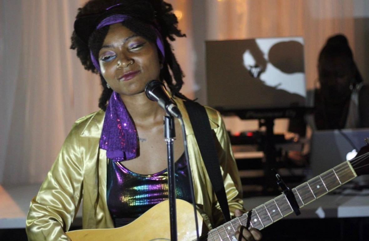 Singer performing with guitar at LongHouse event